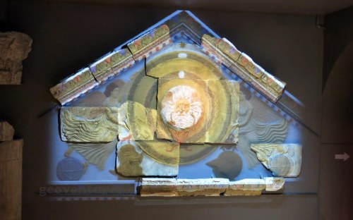 Remains of the temple pediment, with a projected image of what it used to look like